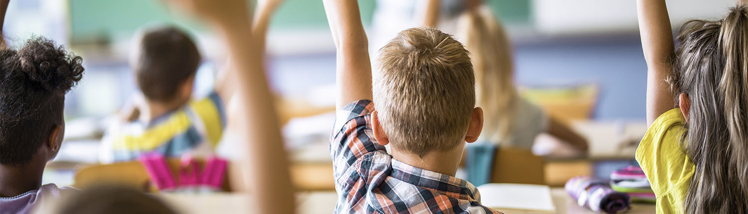 Students raising hands in a private school classroom