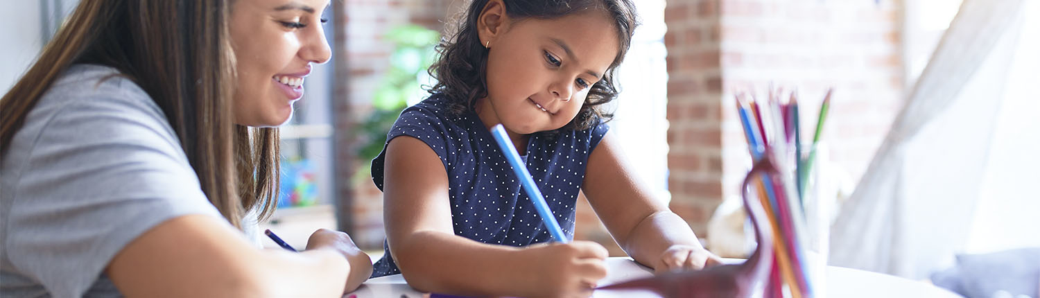 Mother helping daughter write a letter